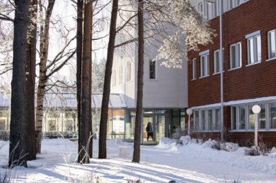 Luminen ja aurinkoinen kuva Lapin yliopistosta takapihalta kuvattuna.