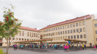 Kuva harjoittelukoulusta. Pihalla on oppilaita.