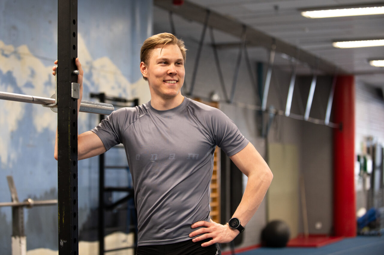 Mies hymyilee kameralle urheiluvaatteissa.