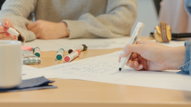 Käsi kirjoittamassa tussilla suurelle paperille, fasilitointivalmennus