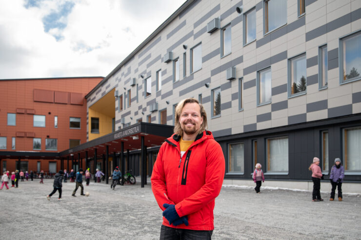Punatakkinen mies Ounasrinteen koulun edessä.