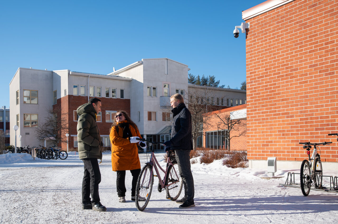 Korkeakouluyhteisön jäseniä aurinkoisena talvipäivänä yliopiston edustalla.